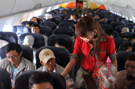 Anh Dương Châu Toàn cùng tiếp viên VietJet Air tặng nón lá bài thơ cho hành khách