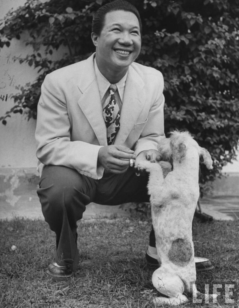 Bảo Äại bắt tay vá»›i chú chó cá»§a mình ở Hồng Kông, tháng 6/1948. Vừa là cá»±u hoà ng, vừa có phong thái cá»§a má»™t tay chÆ¡i phóng túng, Bảo Äại là mẫu ngưá»i rất hấp dẫn vá»›i các quý bà . Vì váºy mà ông có rất nhiá»u tình nhân. Ông cÅ©ng nổi tiếng là mê ăn chÆ¡i, hưởng lạc. Tại Hồng Kông, Bảo Äại đã đổi tên thà nh Wang Kunney tiên sinh để tiện chÆ¡i bá»i. Dân thượng lưu Hồng Kông đồn đại rằng: muốn xem mặt ông vua nước Nam chỉ cần tìm ở 14 tiệm nhảy, nếu không thấy thì tìm ở các sòng bạc.