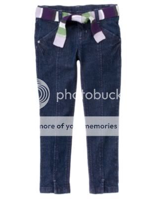 Dark blue denim jeans are slim cut down through ankles with a purple 